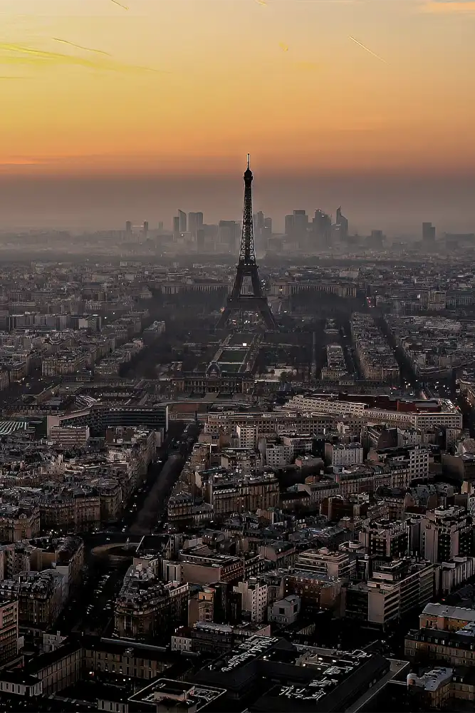 Aerial view of Paris at sunset with the Eiffel Tower and La Défense business district in the background, as seen from the Tour Montparnasse, France